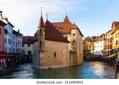 ANNECY, FRANCE - DECEMBER 30, 2021: Scenic view of Annecy old town with ancient stone fortified castle Palais de l Isle on island in Thiou river flowing between colorful houses on sunny winter day