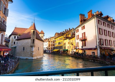 ANNECY, FRANCE - DECEMBER 30, 2021: Scenic view of Annecy old town with ancient stone fortified castle Palais de l Isle on island in Thiou river flowing between colorful houses on sunny winter day