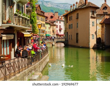 ANNECY, FRANCE - MAY 13: People sitting at street cafe and walking on the Quai de l'Isle on May 13, 2012 in Annecy, France.