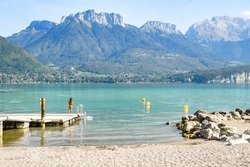 Annecy Lake In France With Turquoise Water, Mountains And Swans