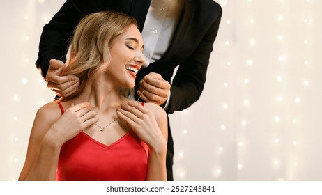 Anniversary Gift. Affectionate Man Presenting Golden Necklace To His Pleased Girlfriend At Romantic Dinner In Restaurant, Copy Space - Powered by Shutterstock