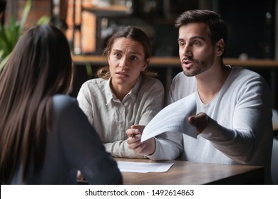 Annoyed angry disappointed customers clients couple holding paper arguing with bank manager fight complain on bad contract terms high mortgage rate demand claim insurance compensation meeting lawyer - Shutterstock ID 1492614863