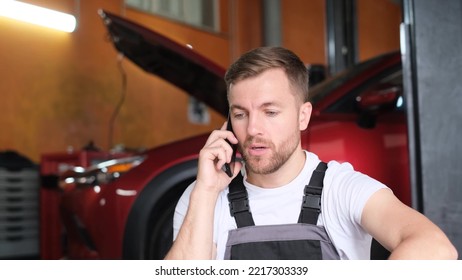 An Annoyed Auto Mechanic Is Sitting In A Car Repair Shop And Talking Rudely To Someone On The Phone