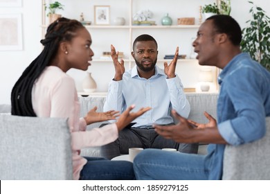 Annoyed Black Psychologist Watching Couple Arguing During Marital Therapy Session, Can Not Manage Conflict, African American Spouses Quarreling In Front Of Family Counselor, Selective Focus