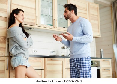 Annoyed Displeased Young Bearded Husband Gesturing Hands While Talking With Raised Voice To Wife In Domestic Kitchen