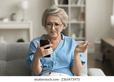 Annoyed frustrated mature retired woman in glasses getting problems with smartphone, trouble with online connection, communication, reading bad news, using mobile phone - Powered by Shutterstock