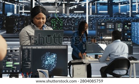 Annoyed high tech server room system admin having trouble doing visual programming with irked woman in server room having buggy issues.