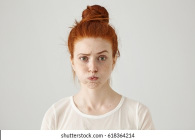 Annoyed Irritated Young Red-haired Female With Freckles Blowing Her Cheeks, Frowning, Feeling Frustrated With Something. Human Facial Expressions, Emotions And Feelings. Fatigue Or Boredom Concept