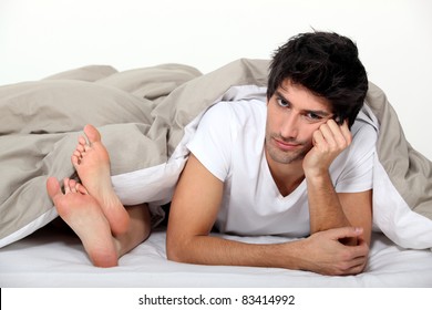 Annoyed Man Lying Next To A Woman In Bed