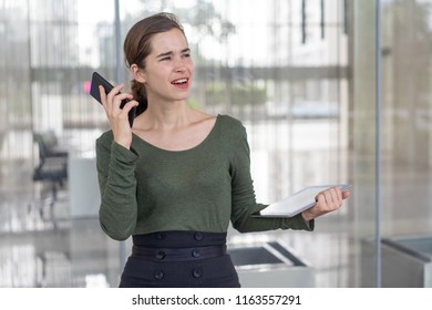 Annoyed Manager Distracted From Phone Call. Young Business Woman In Casuals Walking Outside Office, Holding Tablet, Shouting At Colleagues And Trying To Talk On Cell. Multitasking Or Stress Concept