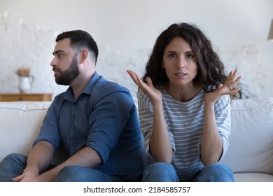 Annoyed married couple sitting on couch apart, after conflict, arguing, row. Serious angry wife looking at camera, tired husband turning away. Marriage crisis, counseling, relationships concept - Powered by Shutterstock