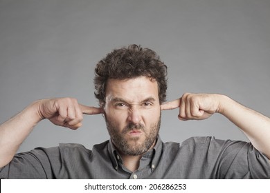 Annoyed Mature Man Plugging Ears With Fingers