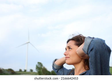 Annoyed Woman Covering Ears With Hands Suffering Windmill Noise In A Wind Farm