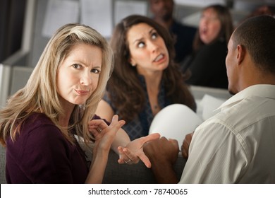 Annoyed Woman With Coworkers In Office Cubicle