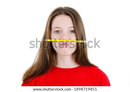 Annoyed young girl, funny student  playing holding pen between nose and lips as mustache looking at camera,  playful bored after working long hours. Isolated on white background