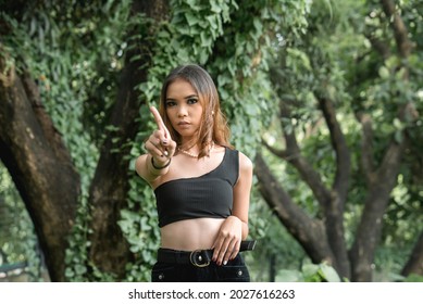 An annoyed young lady with bad attitude says no by waving her finger. Expression of denial or restriction. Irritated and mad at catcalling her sexy outfit.