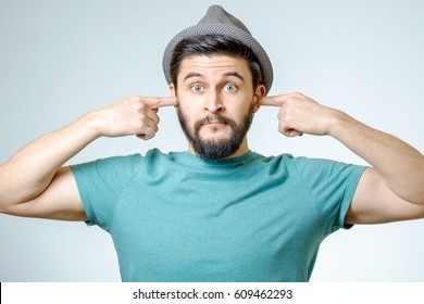 Annoyed Young Man Plugging Ears With Hands Isolated