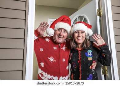 Annoying inlaws wearing santa hats welcoming family on the holiday - Powered by Shutterstock