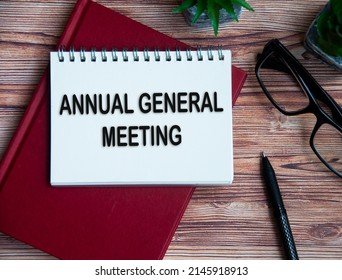 Annual General Meeting Text On Notepad With Office Setting Background.