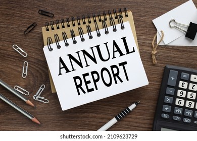 ANNUAL REPORT. two notebooks with a spring on a wooden background with a pencil calculator pen business concept. Office concept. - Shutterstock ID 2109623729