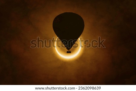 Annular solar eclipse in dark red sky. Hot air balloon rising high into sky. Solar eclipse is mysterious natural phenomenon when Moon passes between planet Earth and Sun