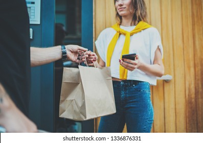 Anonimous delivery food service at home. Man courier delivered the order no name bag with food. - Shutterstock ID 1336876331