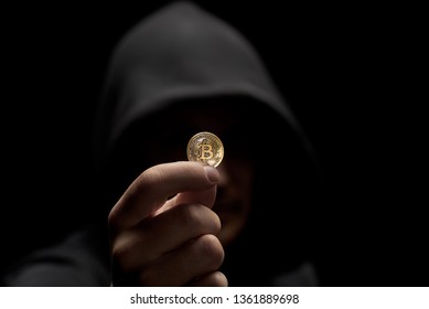 Anonimous Hacker Holding Bitcoin In Hand Dangorous Criminal In Shadow