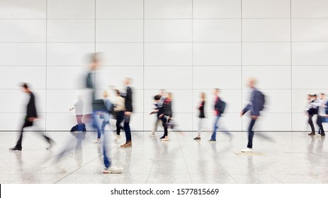 Anonymous blurred business people rush through trade fair hall or airport