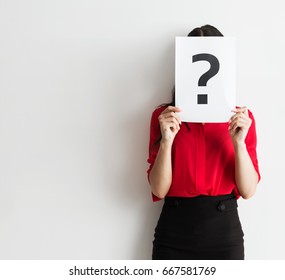 Anonymous business woman holding a question mark - Shutterstock ID 667581769