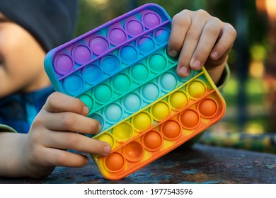 Anonymous Child Hold In His Hands Sensory Toy Pop It And Shows It In Front Of Himself.Rainbow Color.Antistress Toy For Children And Adult.