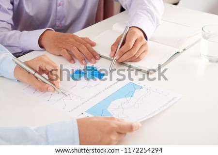 Crop hand of anonymous woman playing antique turntable made with cardboard box on yellow table over animal print textile print on blue background