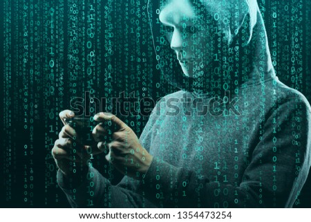 Anonymous computer hacker over abstract digital background. Obscured dark face in mask and hood. Data thief, internet attack, darknet fraud, dangerous viruses and cyber security.