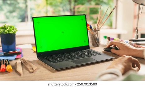 Anonymous Designer Working on a Laptop Computer with Mock Up Green Screen Chromakey Display with Motion Tracker Placeholders. Photo Template for Artistic Content Creation and Presentation - Powered by Shutterstock