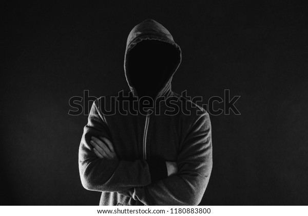 暗い背景に腕を組んだ隠れ家の中の匿名で顔の見えない男 インターネット活動のコンセプトで お忍びで謎の犯罪者 の写真素材 今すぐ編集