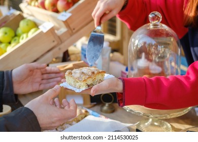 Anonymous female seller giving piece of fresh pastry to crop male client during work in bakery on street market - Powered by Shutterstock