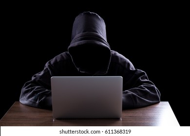 Anonymous hacker with laptop in the dark. Cyber security concept