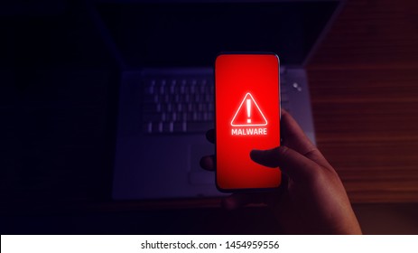 An anonymous hacker and uses a malware with mobile phone to hack password the personal data and money from Bank accounts. The concept of cyber crime. - Shutterstock ID 1454959556