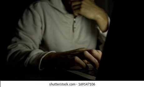 Anonymous male on a laptop at night. Concept of internet addiction