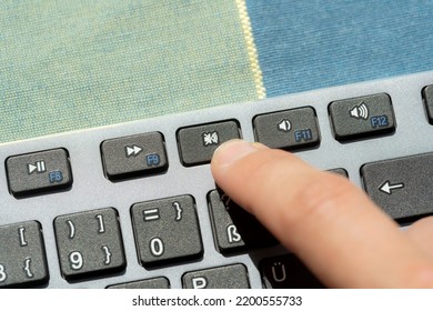 Anonymous Man Pressing The Mute Button, Sound Off Key On A Modern Computer Keyboard, Hand, Finger Closeup, Detail. Muting, Turning Audio Off, Peace And Quiet, Silence Abstract Concept, One Person