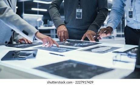 Anonymous Managers Standing Around a Table, Having a Work Meeting, Discussing Blueprints with Industrial Equipment Design. Engineers Standing Around Table in Office. Close Up on Hands.