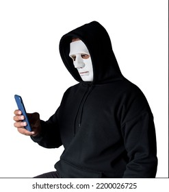 Anonymous Masked Hacker Is Using Smartphones To Penetrate Financial Data With Clipping Path, Hacking And Malware Concept.