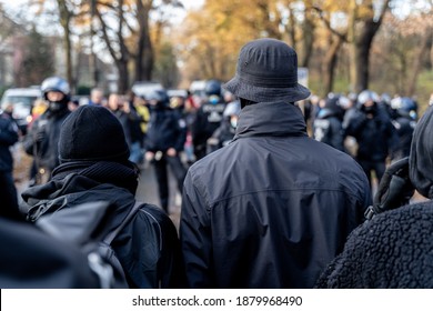 Anonymous Masked Left Wing Antifa, Or So Called Black Block Is Standing In Front Of A Riot Police Line With Helmets On In Germany To Block Other Protesters.