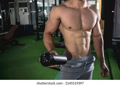 An Anonymous Muscular Man Shaking His Protein Drink. Post-workout Beverage After Working Out At The Gym.