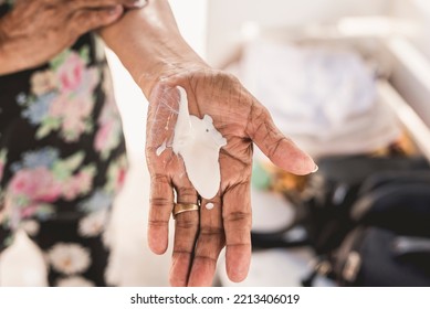 An Anonymous Old Woman Applying Sunscreen Lotion. Sunblock Cream On The Palm Of An Older Person Outside, Possibly At The Beach.