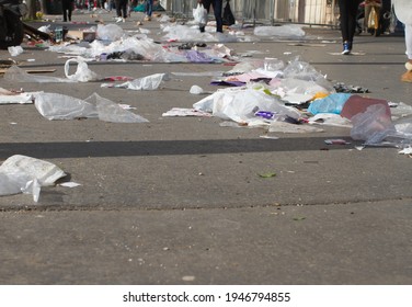 anonymous pedestrians walking through plastics and garbage polluting streets and flying through the pavements in Paris - Shutterstock ID 1946794855