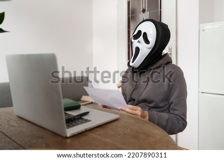 Anonymous person with ghost mask checking papers. Energy crisis and inflation concept