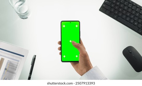 Anonymous Person Using a Smartphone with Mock Up Green Screen Chromakey Display with Motion Tracker Placeholders. Manager Browsing Online, Swiping and Tapping on the Phone. Top Down View - Powered by Shutterstock