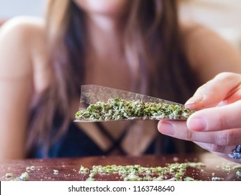 An Anonymous Starting To Roll A Marijuana Joint.