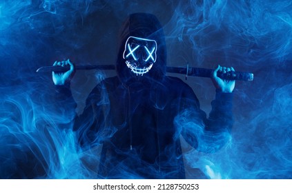 Anonymous with a sword in hand. Dangerous hacker in mask. Internet, cyber crime, cyber attack, system, game, breaking and malware concept. Dark smoke background.