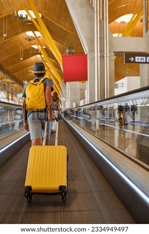 Anonymous traveler with suitcase on travolator